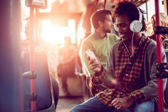 Student listening to headphones while on a bus