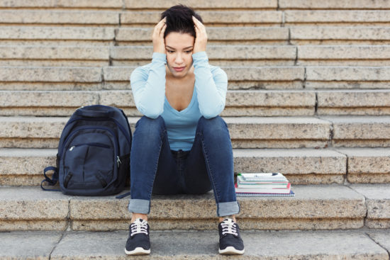 Stressed student sitting on steps outside
