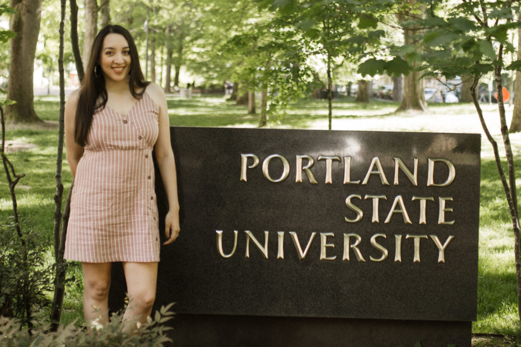 Izela Schutz Michel in front of Portland State University signage